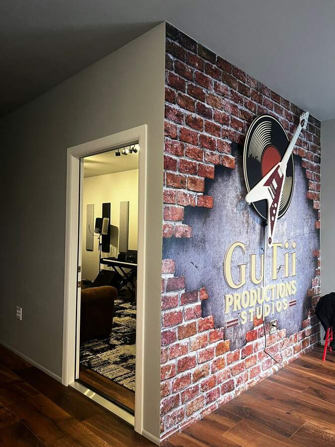 Recording booth with the Gutii Productions signature wall